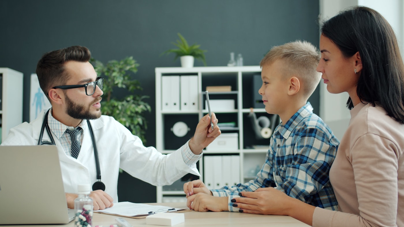 Pneumopediatra conversando com família em consultório